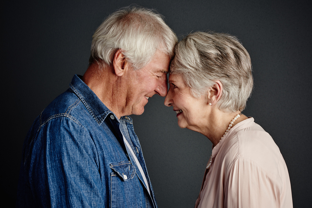 Älters Paar lächelt sich verliebt an. / iStock/Tinpixels Älters Paar lächelt sich verliebt an.